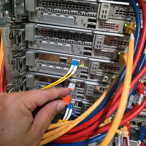 Fiber and network cabling being patched on rack servers